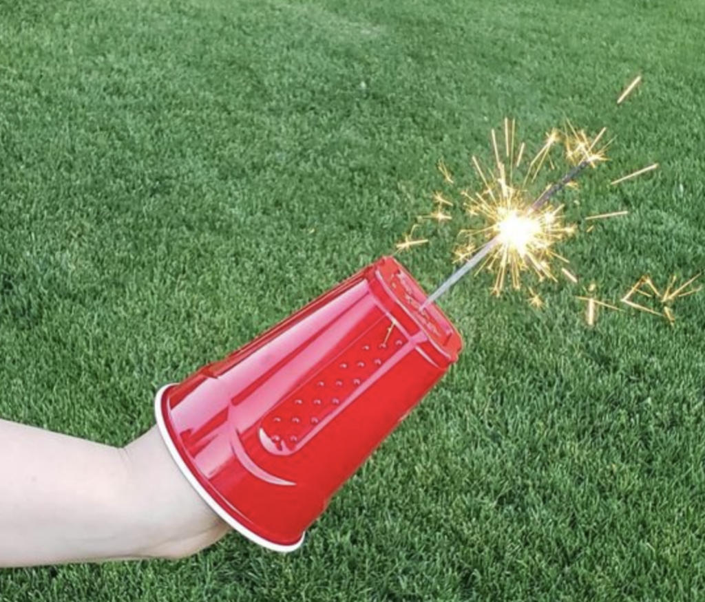 Oversee sparkler with a solo cup protecting the hand.