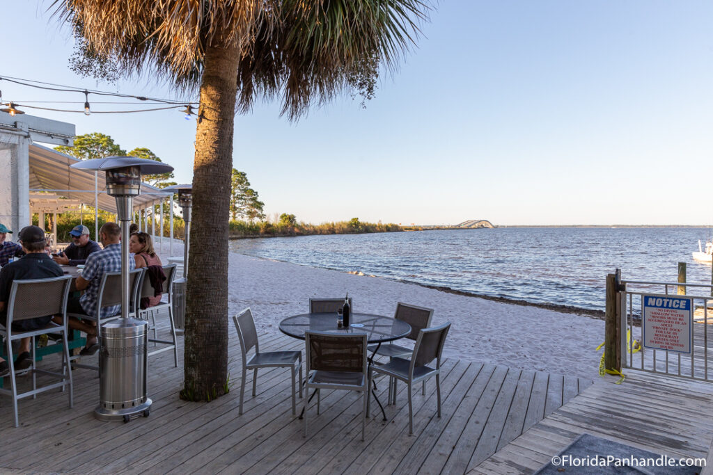 The Bay features cozy outdoor seating right on the sandy beach of Choctawatchee Bay.