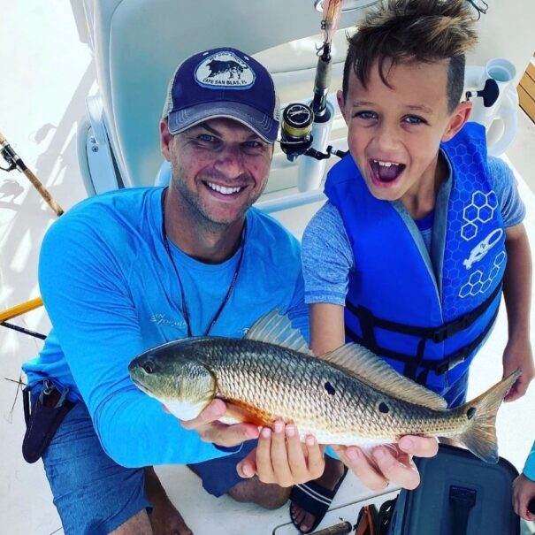 Father and son enjoy fishing, made possible by 30A Inshore Charters. 