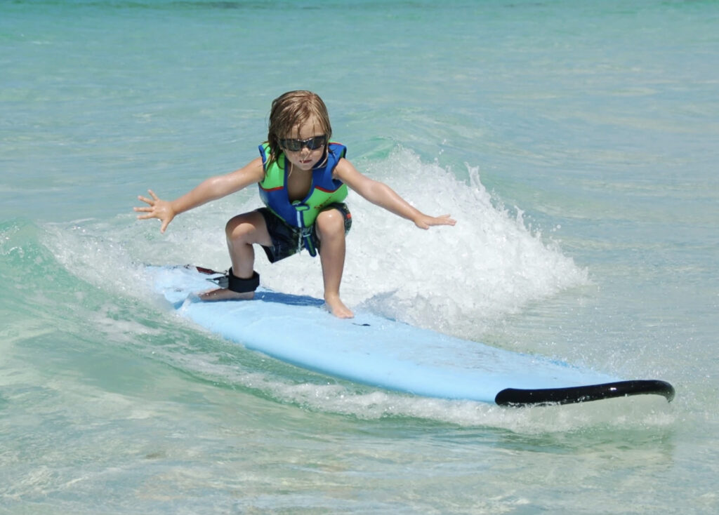 Young boy learns to surf at 30A's Austin Magee’s Surf School.